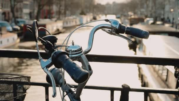 Handheld close-up opname van het stuur van de fiets geparkeerd op de brug — Stockvideo