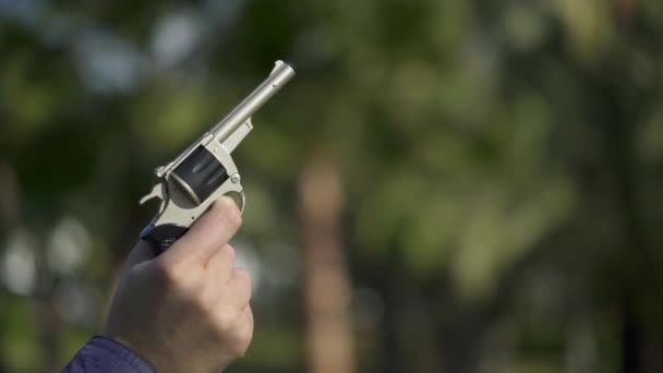 Отец стреляет в воздух из детского пистолета во дворе. Медленный выстрел — стоковое видео