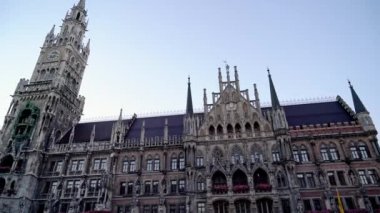 Münih şehir merkezi Marienplatz 'daki Yeni Belediye Binası' nın ön cephesinin Gimbal gerçek zamanlı çekimi. Belediye binası Almanya 'nın sembolüdür..