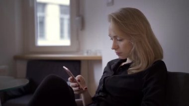 Sarışın bir kadının telefonda mesajlaşırken çekilmiş el resmi.