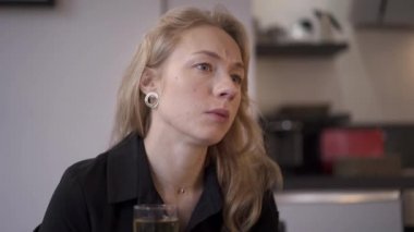 Sarışın bir kadının bir bardak şampanya içerken çekilmiş bir fotoğrafı.