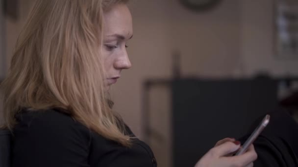 Prise de vue à la main de femme blonde assis textos au téléphone 