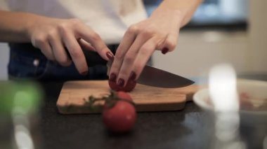 Ahşap bir tahtada kiraz doğrayan bir kadının el kamerası görüntüsü.