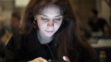 Bir restoranda telefon yazarken kadın kahverengi saçlarını kapat.