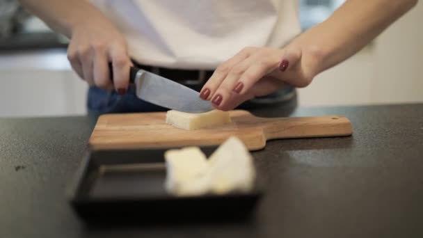 Tutup tangan wanita memotong keju parmesan di papan potong — Stok Video