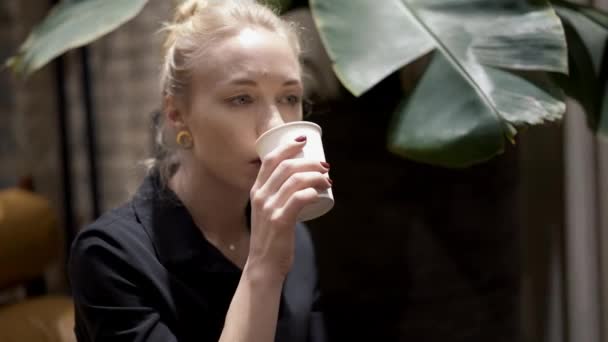 Handheld close up of blonde woman with hair in a bun drinking wine — Stock video