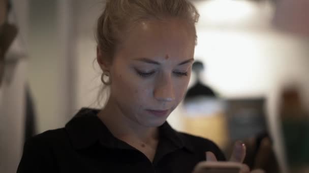 Close-up van vrouwelijke blonde haar met een telefoon, typen — Stockvideo