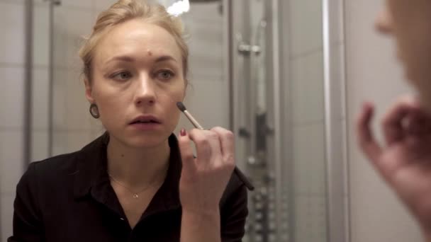 Handheld shot of woman doing make up in the bathroom — Stockvideo