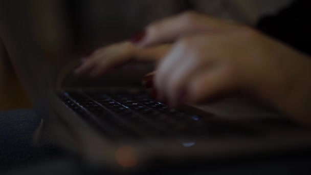 Закрытие женских рук с ноутбуком, печатающим ночью — стоковое видео