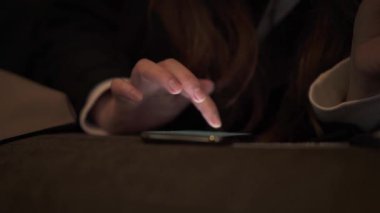 Close up of female hands with smartphone and credit card at night