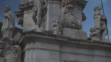 Tilt up shot of Holy Trinity statue in Budapest under blue sky