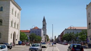 Münih, Almanya - 25 Haziran 2019: Bavyera Ordusu Zafer Zaferi Kemeri 'nden gündüz vakti Feldherrnhalle' e, Münih, Almanya 'ya giden trafiğin Pan çekimi. Zafer Kemeri yakınlarındaki Münih 'te trafik.