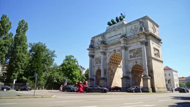 Мюнхен, Німеччина - 25 червня 2019: Тріумфальна арка перемоги баварської армії в денний час, Мюнхен, Німеччина. Транспорт у Мюнхені поблизу арки перемоги. — стокове відео