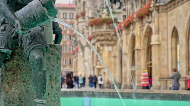 Bloqueado en tiempo real plano medio de la figura de un niño en la famosa fuente de peces en la Marienplatz en Munich, Alemania . — Vídeos de Stock