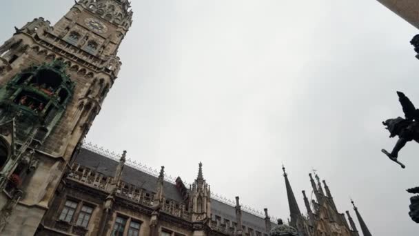 Left to right real time low angle shot of New Town Hall on Marienplatz the city centre of Munich. The town hall are symbols of the city, Munich, Germany. — Stock Video