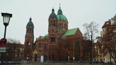 MUNICH - NOVEMBER 22: Right to left pan real time establishing shot of the Church of St. Luke, located on the banks of the river Isar on an autumn day, November 22, 2018 in Munich, Germany.