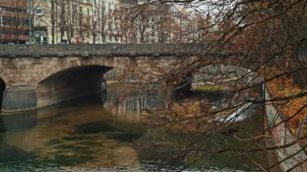 MUNICH - NOVEMBER 22: Right to left pan real time establishing shot of a Maximilian bridge on the Isar river in the German city Munich, November 22, 2018 in Munich, Germany. — ストック動画