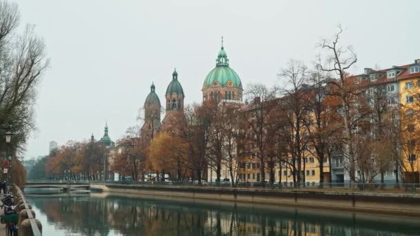 Left to right pan real time shot of the Church of St. Luke, located on the banks of the river Isar on an autumn day. — Stock video