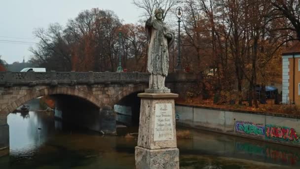MUNICH - NOVEMBRO 22: Esquerda para a direita pan tempo real estabelecer tiro de uma estátua em uma ponte, localizado no rio Isar, em Munique, 22 de novembro de 2018 Munique . — Vídeo de Stock