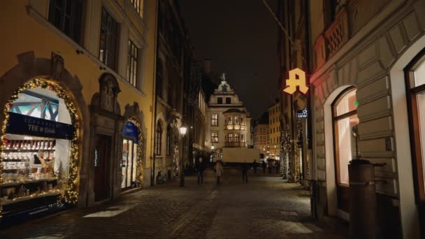 MUNICH - NOVEMBER 22: Locked down real time establishing shot of the evening street in Munich. People walk around the evening city, November 22, 2018 in Munich. — Stockvideo