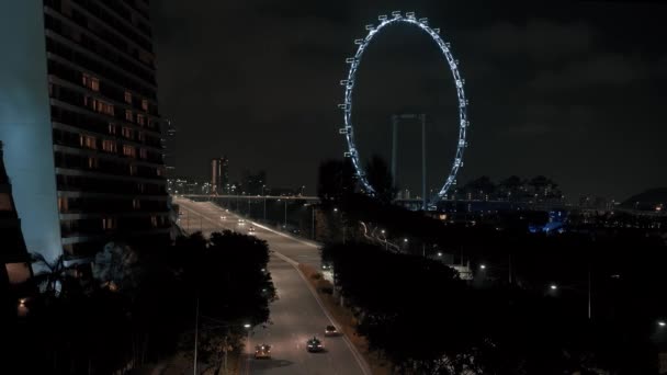 Заблокирован в режиме реального времени при создании снимка ночного движения в Сингапуре с видом на колесо аттракциона. Концепция путешествия по Азии . — стоковое видео
