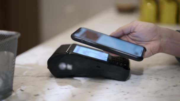 A close up of customer paying with a phone with contactless method — 비디오