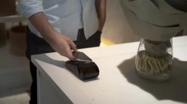 Çiçekçide bukete para ödeyen adamı yukarı kaldır.
