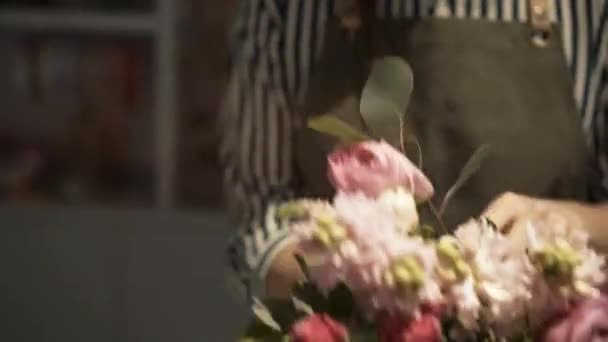 Gros plan du fleuriste femelle faisant un bouquet de fleurs roses — Video