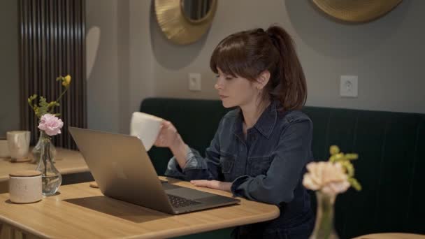 Nahaufnahme einer Frau, die in einem Café mit einem Laptop arbeitet — Stockvideo