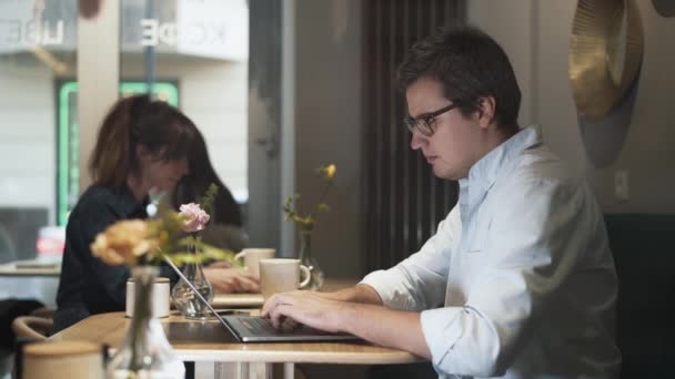 Портативний знімок фрілансера людини з ноутбуком п'є каву в приміщенні — стокове відео