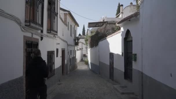 Handheld shot of man walking in Ronda city residential houses — Stock Video