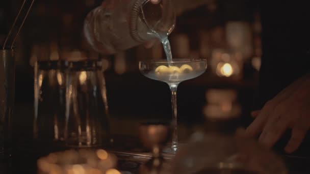 Plan rapproché en temps réel d'un barman versant un cocktail dans un verre dans un bar à Bangkok, Thaïlande . — Video