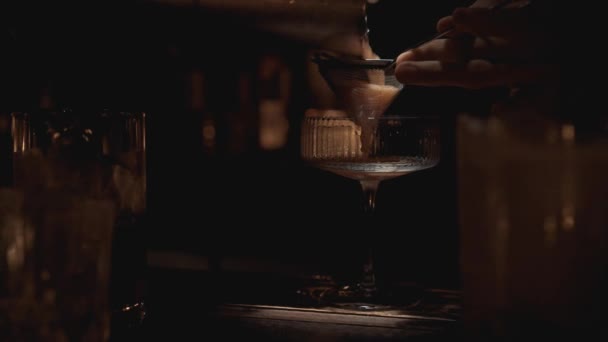 Handheld real time close up shot of a bartender pouring a cocktail into a glass at a bar in Bangkok, Thailand — Stock Video