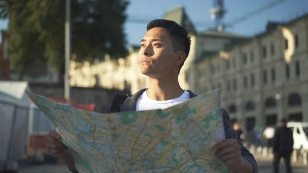 Retrato de vista lateral de un joven asiático mirando un mapa. Turista en Moscú. Moscú es la capital de Rusia . — Foto de Stock