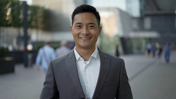 Porträtt av en ung glad asiatisk affärsman som ler. Begreppet framgång i karriären. — Stockfoto