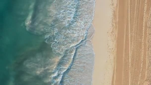 Vue aérienne de drone survolant les vagues azur et la plage de sable, pas de personnes 