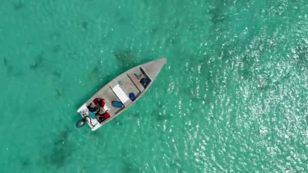 Drohne zoomt aus der Luft von kleinem Boot mit Menschen auf dem Meer — Stockvideo