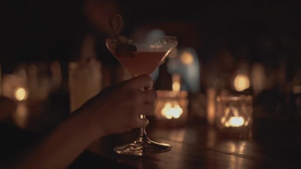 Nahaufnahme einer Theke in einer Bar in Bangkok. Der Mensch trinkt einen Cocktail, im Hintergrund brennen Kerzen. — Stockvideo