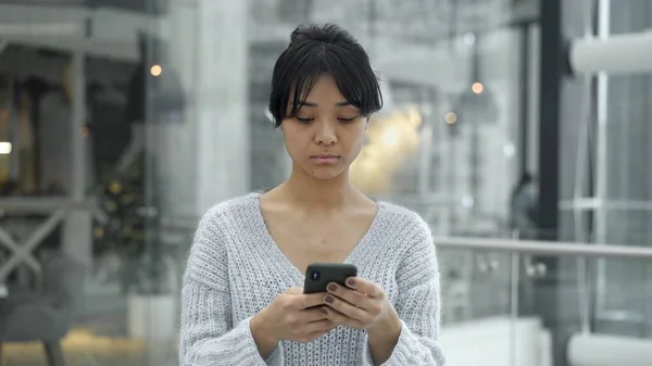 Handheld portret shot van aziatische vrouw scrollen telefoon — Stockfoto