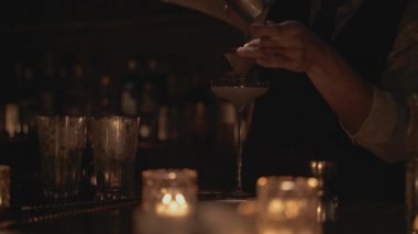 Bir barmenin bardağa kokteyl dökerken gerçek zamanlı görüntüsü. Barmen Bangkok, Tayland 'da bir barda kokteyl hazırlıyor..