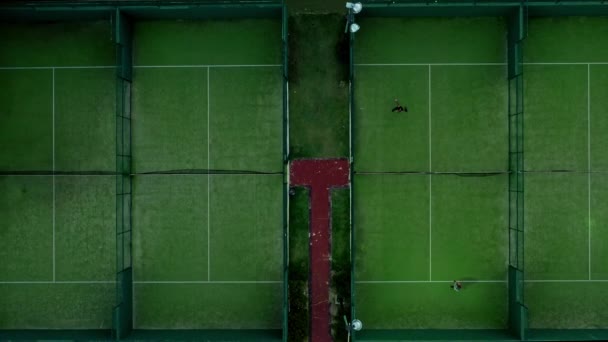 Drone zoom top shot volando sobre canchas de tenis con jugadores — Vídeos de Stock