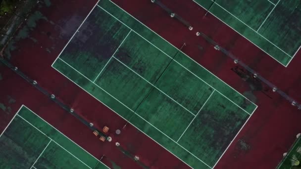 Drohne zoomt Top-Schuss ab und fliegt mit Menschen über Tennisplätze — Stockvideo