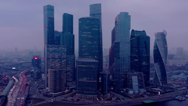 MOSCOW, RUSSIA - 2019. június 10.: Nagyítás Moszkva felhőkarcolóiról ködös lila ég alatt — Stock videók