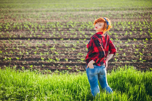 Meisje op de achtergrond van een groen veld — Stockfoto