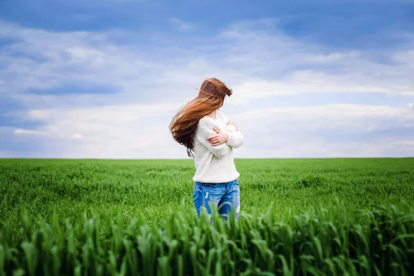 Girl is spinning in a field with green grass — Stock Photo, Image