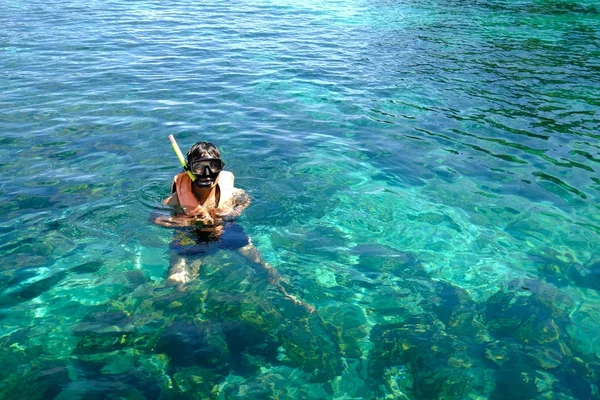 A man floating in the middle of crystal clear water at Andaman Sea.