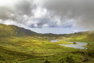 Portekiz, Azores 'deki Corvo adasındaki Corvo Caldera üzerinde dramatik bulutlar hızla dans ediyor..