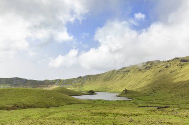 Açık mavi gökyüzü Portekiz, Azores 'deki Corvo adasındaki Corvo Krateri' nin havzasına yükselir..