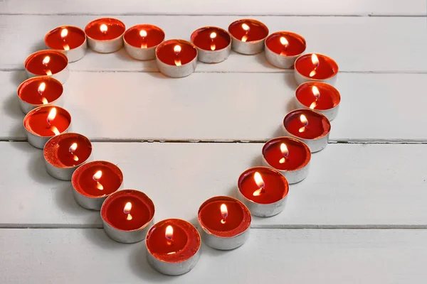 A close up image of red tea light candles arranged in a heart shaped pattern.