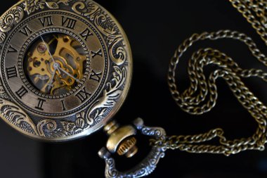 Bir eski antika cep saati ve siyah cam masa üstü zincirinde bir üstten görünüm görüntüsü. 